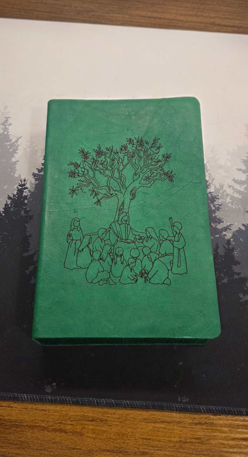 Green leather journal engraved with a tree and gathering scene