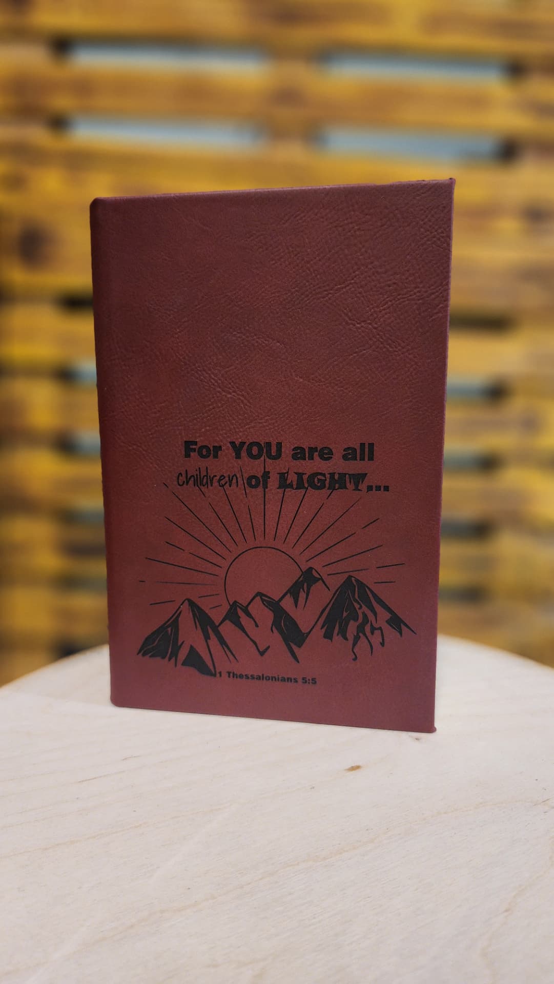 Maroon leather journal engraved with a mountain sunrise and 1 Thessalonians 5:5